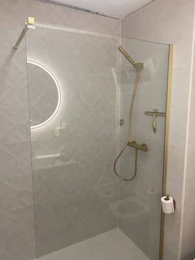 Mampara de ducha en oro cepillado instalada