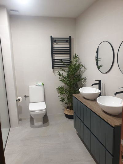 Baño completo reformado con mampara, sanitarios y grifería